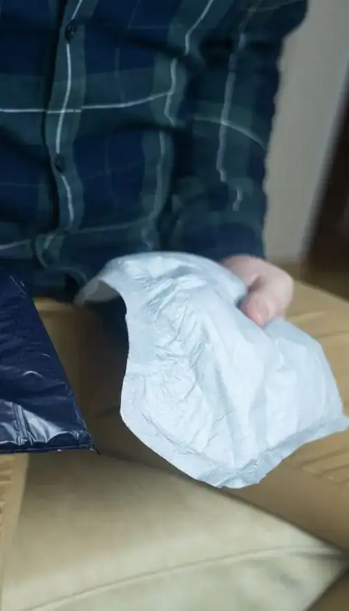 Image of man holding incontinence pads as part of overactive bladder treatment 